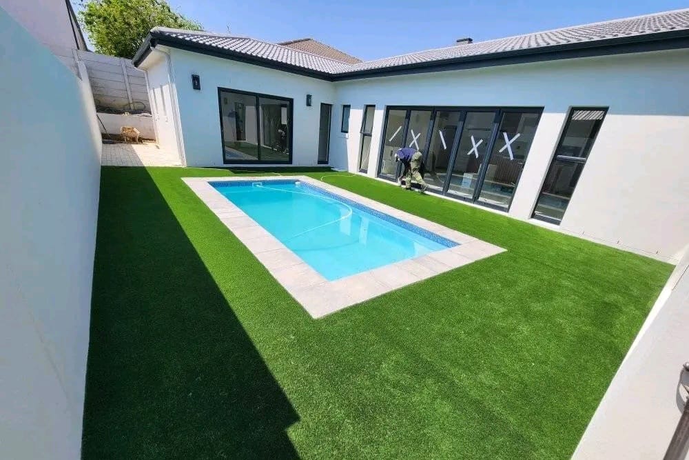 Pool surround with stone copings and fresh lawn installed by Stellar